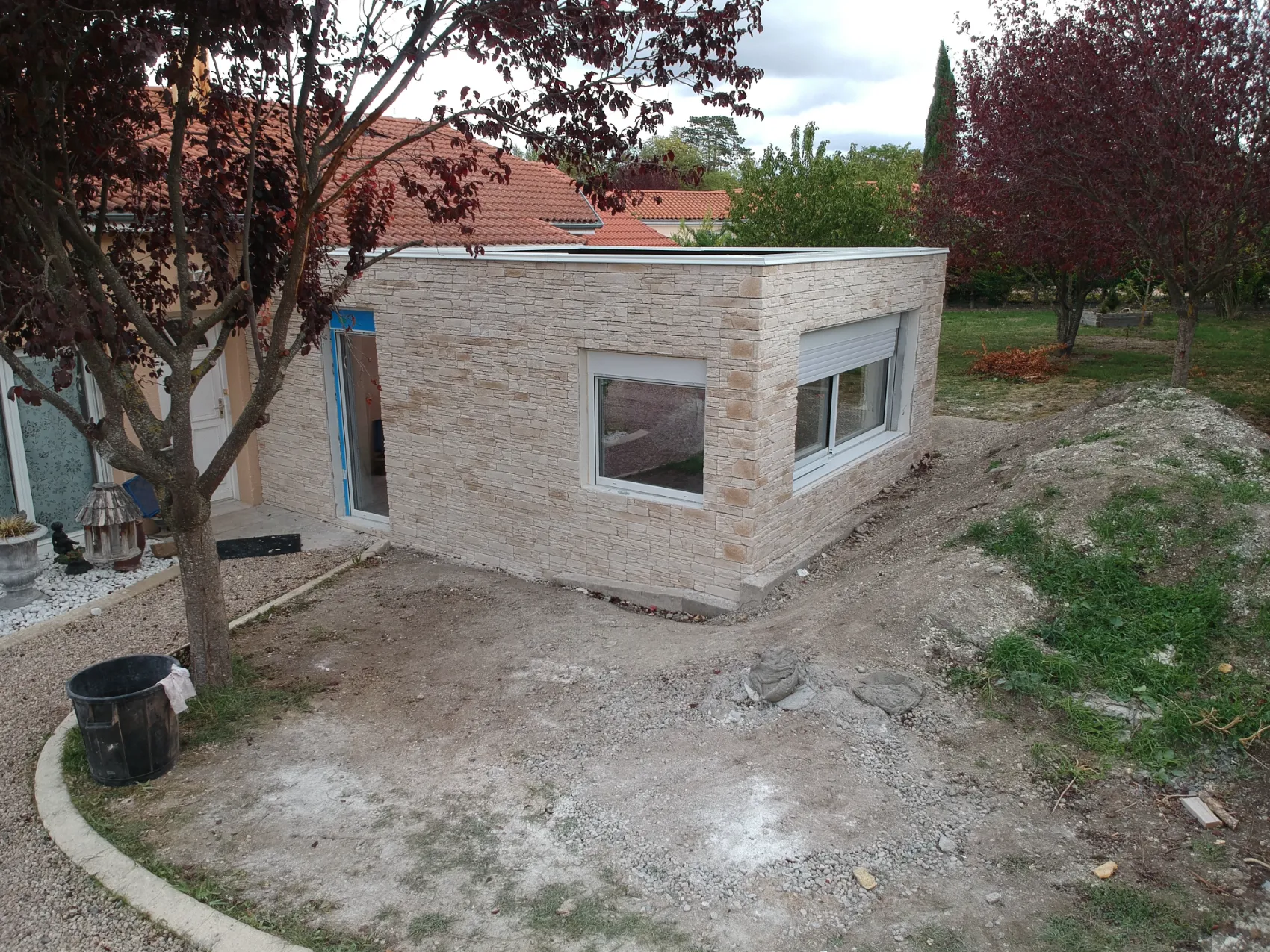 Extension de maison en ossature métallique légère habillée d'un parement en pierre naturelle