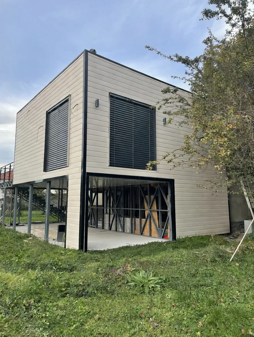 Extension de maison sur pilotis en ossature métallique avec bardage bois